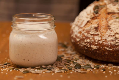 Close-up of sourdough starter and loaf on table