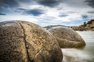 Rocks on beach against sky