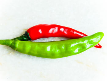 High angle view of red chili peppers on white background