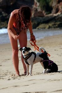 Full length of young woman with dog on beach