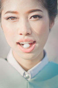 Close-up portrait of woman eating candy