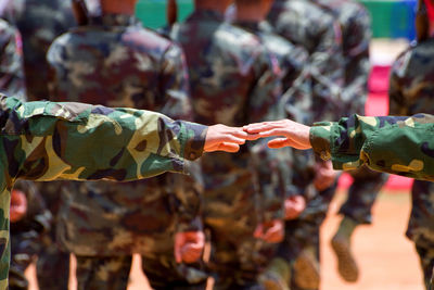 Cropped image of army soldiers touching fingers