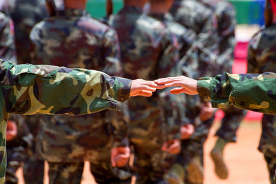Close-up of hands with people in background