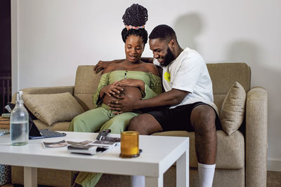 Pregnant woman sitting on sofa with boyfriend at home