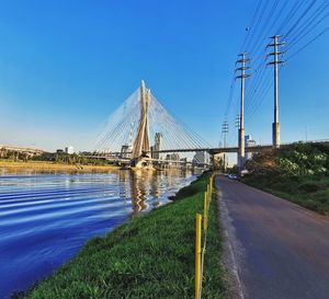 Bridge over road against clear blue sky