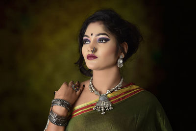 Portrait of a beautiful young woman over black background