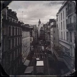 Buildings in city against cloudy sky