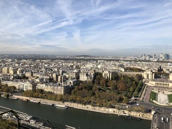 High angle view of city by river against sky