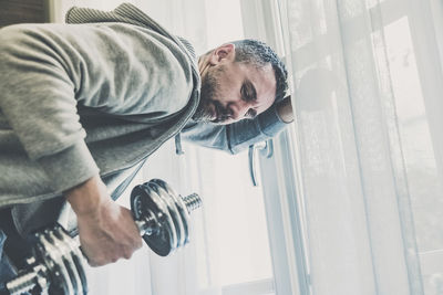 Sporty man working out and trains at home. fit male doing exercise. wellness, health, sport concept