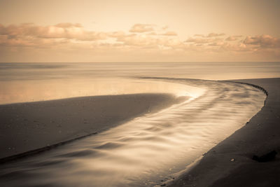 Scenic view of beach against sky during sunset