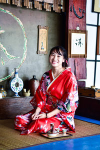 Portrait of smiling young woman sitting at home