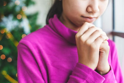 Midsection of girl praying at home