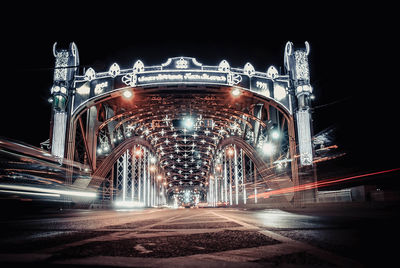 Illuminated bridge in city at night