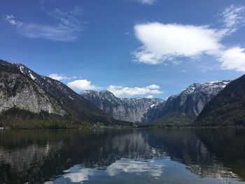 Scenic view of lake and mountains against blue sky