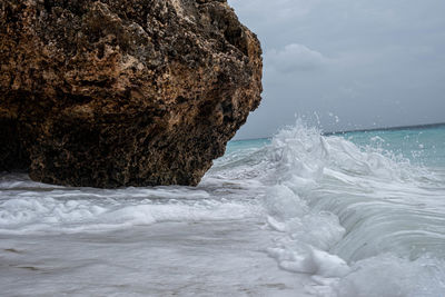 Rock formation in sea against sky