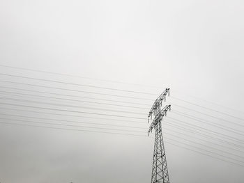 Low angle view of electricity pylon against sky