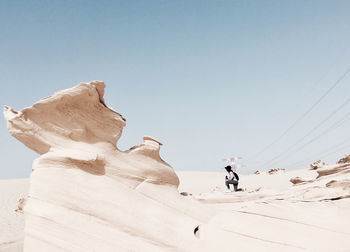 Low angle view of people walking on sand dune