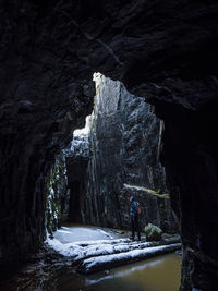 View of tourist in rock crevice at winter