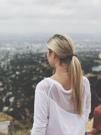 Rear view of woman standing against cityscape