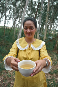 Portrait of smiling mid adult man holding tea cup