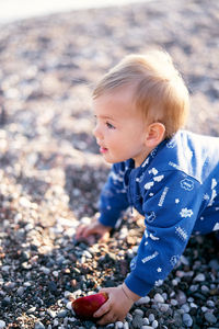 Full length of cute boy lying on pebbles