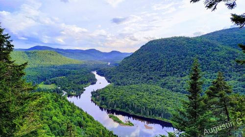 Scenic view of river amidst mountains against sky