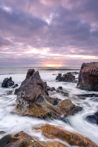 Sunset at the rocky beach at vila nova de gaia, portugal.