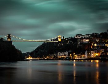 Illuminated bridge and cityscape by night