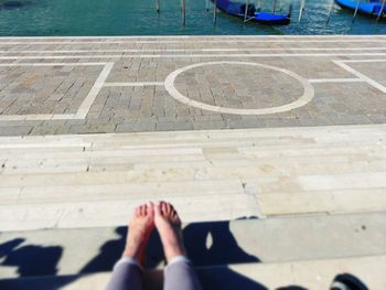 Low section of woman on footpath at swimming pool