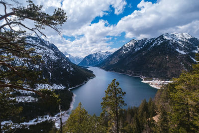 Scenic view of lake by mountains against sky