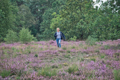 Woman running on land amidst flowering plants