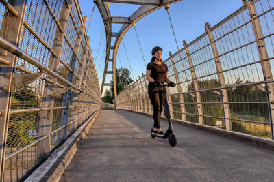 Full length of woman on footbridge against sky