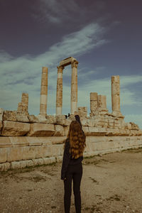 Rear view of man standing against historic building