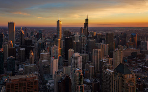 Aerial view of buildings in city during sunset