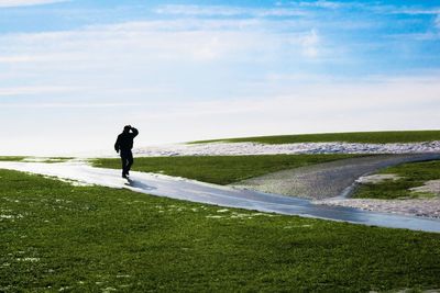 Full length of man standing on beach against sky