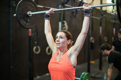 Woman lifting barbell in gym