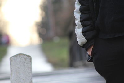 Midsection of man with hand in pocket standing outdoors