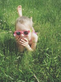 Portrait of girl lying on grassy field