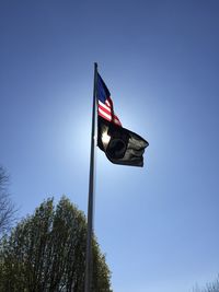 Low angle view of flag flags against clear blue sky