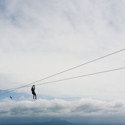 Low angle view of people against cloudy sky