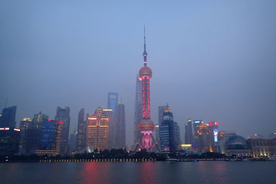 Illuminated buildings in city against sky