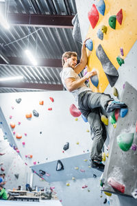 Low angle view of man climbing wall