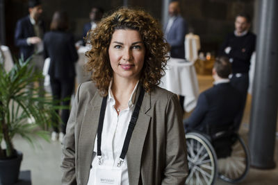 Portrait of businesswoman with curly brown hair at seminar