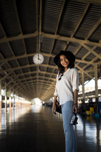 Portrait of woman standing at railroad station