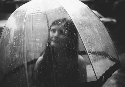 Beautiful young woman in wet umbrella during rainy season