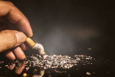 Close-up of hand holding cigarette