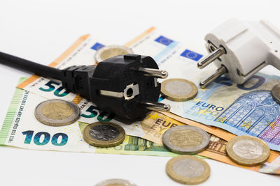 The electric power plugs on euro banknotes and euro coins. concept of rising electricity costs