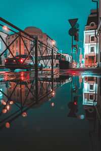 Illuminated street lights by buildings in city at night