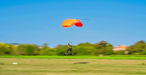 Person paragliding against clear blue sky