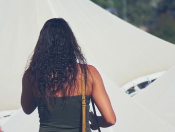 Rear view of woman standing against tents